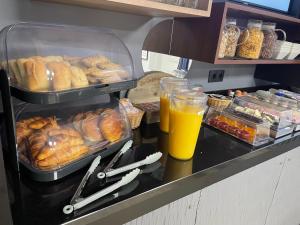 a buffet with bread and a glass of orange juice at Logis Hôtel du Cirque Troyes centre historique in Troyes