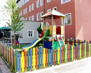 una recinzione colorata con parco giochi di fronte a un edificio di Hotel Servus Europa Suben a Suben