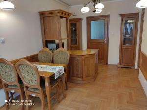 ein Esszimmer mit einem Tisch und Stühlen sowie eine Küche in der Unterkunft Pokoje Gościnne Zakopane in Zakopane
