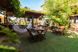 a patio with tables and chairs under a pavilion at Pico dos Piratas in Itarema