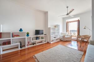 a living room with white shelves and a tv at Charming Apartment in Alfama with River View in Lisbon