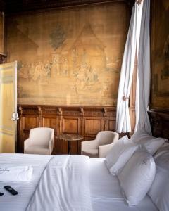 un lit avec deux chaises et un tableau mural dans l'établissement Heirloom Hotels - The Mansion, à Gand