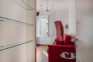 een woonkamer met een rode bank en een spiegel bij Vernazzola Family Apartment by Wonderful Italy in Genua