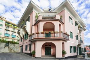 a pink building with a balcony on the side at Vernazzola Family Apartment by Wonderful Italy in Genova