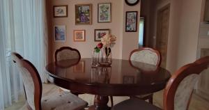 a dining room with a wooden table and chairs at White Column House in Diósd