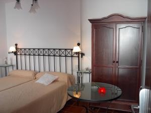 a bedroom with a bed and a table and a cabinet at Casa de los Naranjos in Córdoba