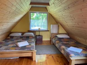 um quarto no sótão com 2 camas e uma janela em Gintaro sodyba em Lazdijai