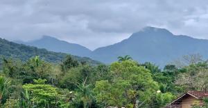 een uitzicht op een bergketen met bomen en huizen bij Apto Ubatuba home - Centro c vista in Ubatuba