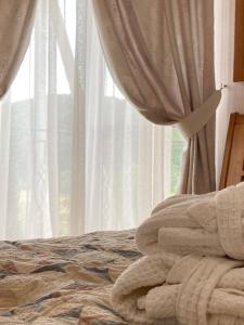 a bed with a blanket and a window with curtains at Mini hotel Solnce Karpat in Polyana