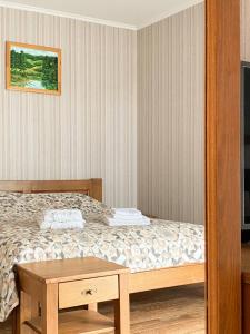 Schlafzimmer mit einem Bett und einem Holztisch in der Unterkunft Mini hotel Solnce Karpat in Poljana