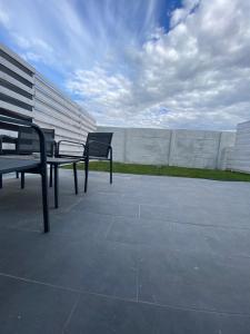 two benches sitting on a patio near a wall at Fly Studios in Tunari