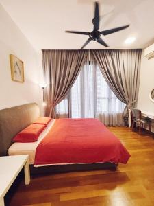 a bedroom with a red bed and a ceiling fan at PROMO Connected train 4 Bedroom ABOVE MALL 20 in Kuala Lumpur