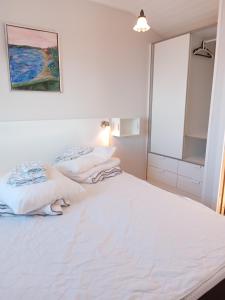two beds in a white room with a mirror at Strand Huset in Faaborg