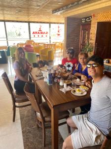 un grupo de personas sentadas en una mesa en un restaurante en Petra Visitors Apartments en Wadi Musa