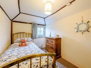 a bedroom with a bed with a teddy bear on it at Sunny House By The Sea in Dymchurch