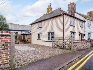 an old house with a wooden gate in front of it at Sunny House By The Sea in Dymchurch