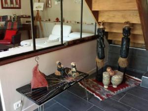 Cette chambre comprend un miroir et une table avec des poupées. dans l'établissement Les Hortensias, à Plouha