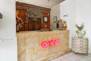 una camera con bancone in legno con cartelli rosa di OYO 1384 Pulau Bali Hotel a Denpasar