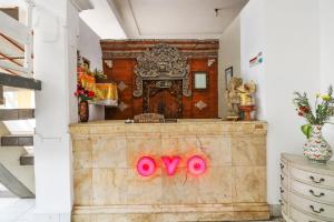 a room with a altar with pink signs on it at OYO 1384 Pulau Bali Hotel in Denpasar
