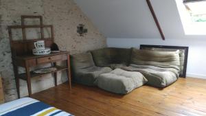 kanapa w salonie z drewnianą podłogą w obiekcie Les Hortensias w mieście Plouha
