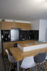 a kitchen with a wooden table and some chairs at Cosy Apartment In The Center Of La Flotte in La Flotte
