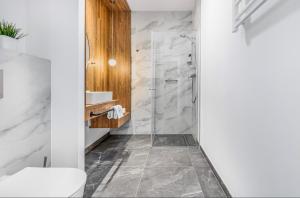 a bathroom with a shower and a toilet at Jantaris B1 - Apartament 20m od plaży in Mielno