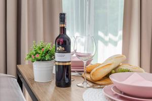 a bottle of wine sitting on a table with a glass at Jantaris B1 - Apartament 20m od plaży in Mielno