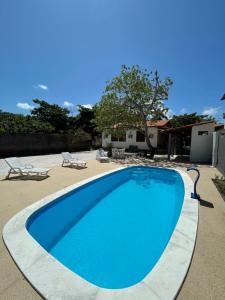 a large blue swimming pool in a yard at Casa na Barra de São Miguel in Barra de São Miguel