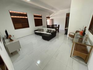 ein Wohnzimmer mit Sofa und Tisch in der Unterkunft Casa na Barra de São Miguel in Barra de São Miguel