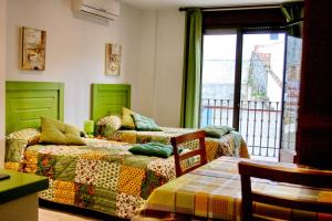 Apartamentos Turisticos Mirayuste في غوادالوبي: غرفة نوم بسريرين ونافذة مطلة