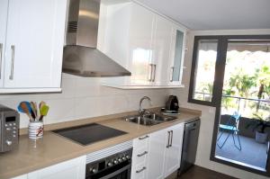 a kitchen with white cabinets and a sink and a window at Marina Raset, 3 dormitorios, centro, by Bookindenia in Denia