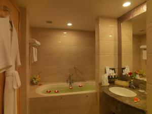 y baño con bañera y lavamanos. en Mysore County Retreat, en Mysore