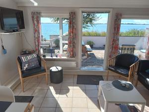 een woonkamer met uitzicht op de oceaan bij Strand Huset in Fåborg