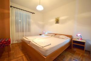 um quarto com uma cama e uma janela em Apartments Petrovic em Malinska
