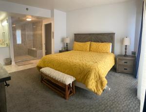 a bedroom with a yellow bed and a shower at River Place Condos #711 3BD in Pigeon Forge