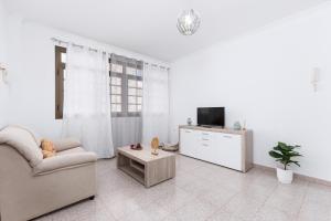 Una sala de estar con un sofá y un televisor. en Home2Book Urban Gran Tarajal II, en Gran Tarajal