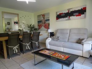 ein Wohnzimmer mit einem Sofa und einem Tisch in der Unterkunft Le Hameau in Mutzig