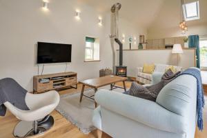a living room with a couch and a tv at Finest Retreats - Min Yr Awel Barn in Fishguard