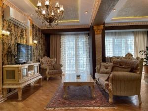 un soggiorno con divano e TV di Park Azure Louvre apartment a Baku