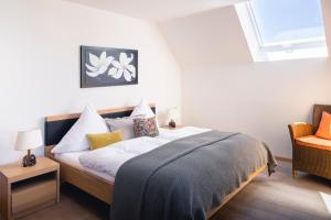 a bedroom with a bed with white sheets and a window at Kurviertel Wohnung II in Überlingen