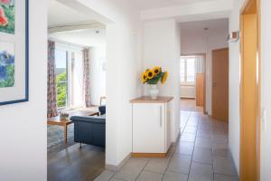 a living room with a blue couch and a vase of flowers at Kurviertel Wohnung II in Überlingen