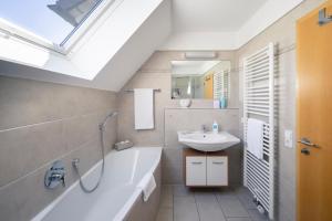 a bathroom with a sink and a bath tub and a mirror at Kurviertel Wohnung II in Überlingen