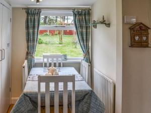 uma sala de jantar com uma mesa e uma janela em Seahorse Chalet em Humberston