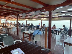 un grupo de personas sentadas en mesas en un restaurante en Molla Hotel Restorant, en Shëngjin