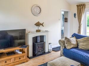 uma sala de estar com um sofá azul e uma lareira em Seahorse Chalet em Humberston