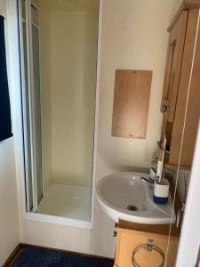 a small bathroom with a sink and a shower at Sunkist, Anderby Creek in Anderby +11 photos