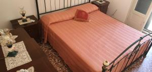 a bedroom with a bed with a red comforter at Casa Vacanza a Punta Secca in Punta Secca