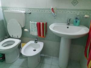 a bathroom with a toilet and a sink at Casa Vacanza a Punta Secca in Punta Secca +12 photos
