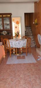 comedor con mesa, sillas y escaleras en Casa Vacanza a Punta Secca, en Punta Secca