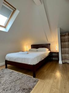 a bedroom with a bed with two lamps on it at Leaside Hotel in Luton